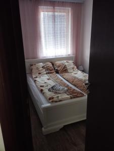 an unmade bed in a room with a window at Andrejić in Ostrovo +8 photos