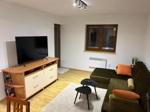 a living room with a couch and a flat screen tv at Kupres Apartman555 in Kupres