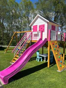ein Spielplatz mit Rutsche und Spielhaus in der Unterkunft Honstryk Relax & Fun Apartamenty z balią i przestrzenią dla rodzin in Krempachy