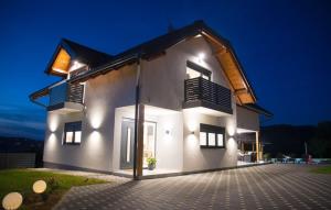 a white house with lights on the side of it at Villa Old Hills by Villas Guide in Ljubešćica