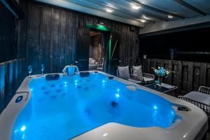 a large blue tub in a room with wooden walls at Lakeside Hotel Plitvice in Plitvička Jezera