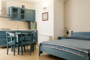a bedroom with a bed and a table and a kitchen at Residence Del Casalnuovo in Matera