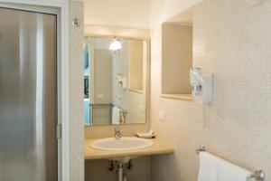 W łazience znajduje się umywalka i lustro. w obiekcie Residence Del Casalnuovo w mieście Matera
