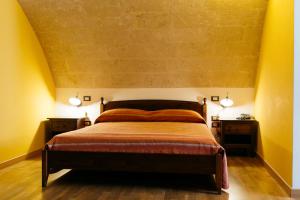 a bedroom with a bed with two nightstands and two lamps at Residence Del Casalnuovo in Matera