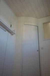 une chambre avec deux armoires blanches et une fenêtre dans l'établissement Le Coin des Cygnes, appartement face au lac d'Annecy avec plage privée, à Doussard