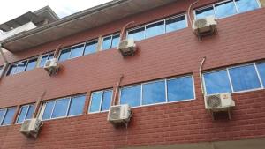 a brick building with air conditioners on the side of it at Hotel Lile John in Bonamakolo