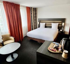 a hotel room with a large bed and a table at Mercure Lyon Centre - Gare Part Dieu in Lyon +59 photos