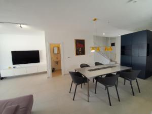 a dining room with a table and chairs and a tv at Casa Bučina in Umag