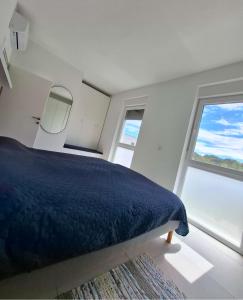 a bedroom with a blue bed and two windows at Casa Bučina in Umag +8 photos