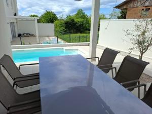 a table and chairs next to a swimming pool at Casa Bučina in Umag
