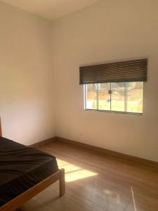 ein Schlafzimmer mit einem Bett und einem Fenster in der Unterkunft Casa Ipê Amarelo in Abadiânia