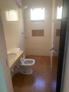ein Badezimmer mit Toilette, Waschbecken und Dusche in der Unterkunft Casa Ipê Amarelo in Abadiânia