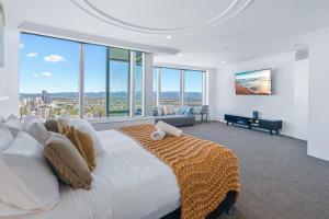 Un dormitorio con una gran cama blanca y grandes ventanales. en L55 Luxury 4BR City And Ocean View Apartment with SPA, en Gold Coast