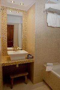 W łazience znajduje się umywalka, lustro i wanna. w obiekcie Fuentepiedra Casa Rural Categoría Superior w mieście Almodóvar del Río +32 zdjęcia