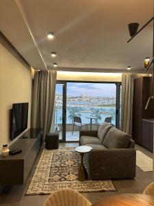 a living room with a couch and a television at Seafront Luxury Apartment in Il-Gżira