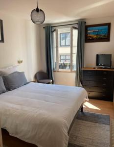 グランビルにあるAppartement Granville hyper centreの大きな白いベッドと窓のある寝室 +9枚の写真