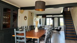 a dining room with a wooden table and chairs at Maison au coeur des vignes in Puisseguin