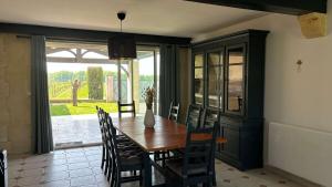 a dining room with a wooden table and chairs at Maison au coeur des vignes in Puisseguin