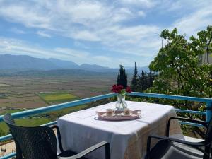 a table with a vase of flowers on top at Xhoni's House in Sarandë