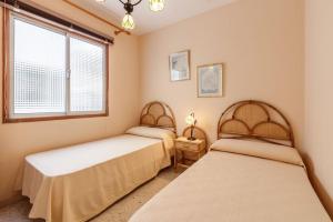 two beds in a room with a window at VV Lorca Beach Puerto Naos in Puerto Naos