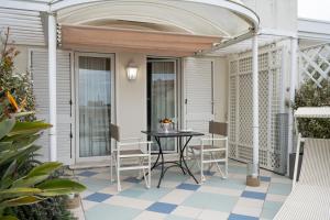 a patio with a table and chairs on a porch at Palace Hotel in Viareggio