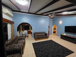a living room with couches and a flat screen tv at 3 bedroom Executive Suite in Suva