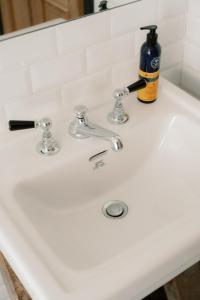 a bathroom sink with a bottle of soap on it at Cabin at Mackay's in Durness