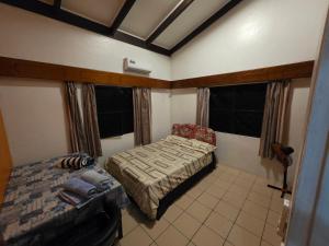 a bedroom with two beds and a chair in it at 3 bedroom Executive Suite in Suva