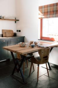 a wooden table in a kitchen with two chairs at Cabin at Mackay's in Durness