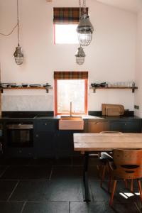 a kitchen with a sink and a wooden table at Cabin at Mackay's in Durness