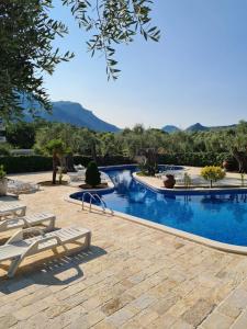 a swimming pool with chaise lounge chairs in a resort at Villa Ponta in Buljarica