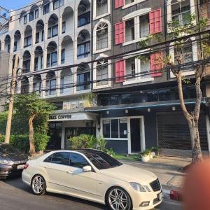 a white car parked in front of a building at Lemon Tree Hostel Khaosan in Bangkok