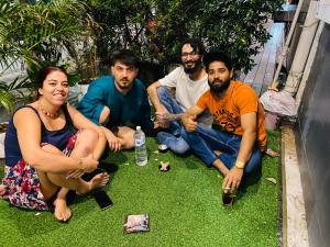 a group of people sitting on the grass at Lemon Tree Hostel Khaosan in Bangkok