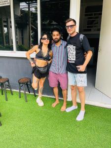 a group of three people standing on the grass at Lemon Tree Hostel Khaosan in Bangkok