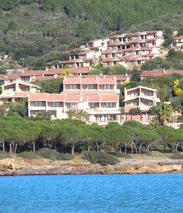 un gruppo di case su una collina vicino all'acqua di Casa Vacanza Porto Corallo a Villaputzu