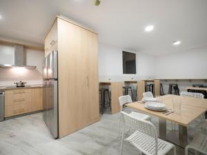 a kitchen and dining room with a table and chairs at Pensión Spa Cruceiro de Pedrouzo in O Pedrouzo