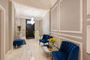 a living room with blue chairs and a table at Charles of Mayfair in London