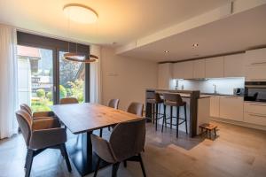 a kitchen and dining room with a wooden table and chairs at Villa Alpjuwel in Oberstdorf