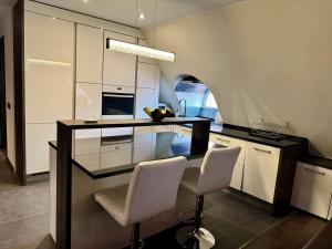 a kitchen with a counter and two chairs in it at I&A Residence - Old Town in Tallinn