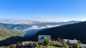 una vista de una montaña con nubes en el valle en Luxury & cosy house in the hills, en Mukteshwar
