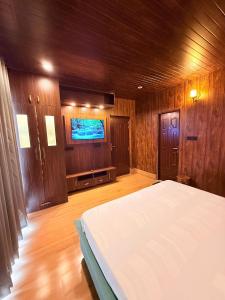 Un dormitorio con una cama y un televisor de pantalla plana. en Luxury & cosy house in the hills, en Mukteshwar 12 fotos más