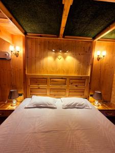 Un dormitorio con una cama grande con dos lámparas. en Luxury & cosy house in the hills, en Mukteshwar