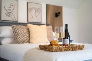 a tray of food and a bottle of wine on a bed at Stylish 2 Bedroom Cottage with Hot Tub and Parking in Bewdley +28 photos