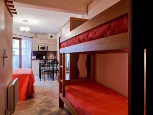 a bedroom with two bunk beds and a kitchen at Studio rénové au centre-ville avec balcon, parking et WIFI - 4 pers - FR-1-512-166 in Brides-les-Bains