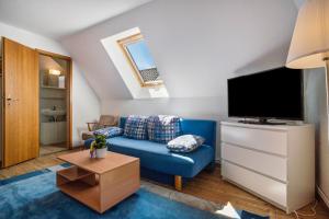a living room with a blue couch and a flat screen tv at Ferienwohnung 4 in Groß Zicker
