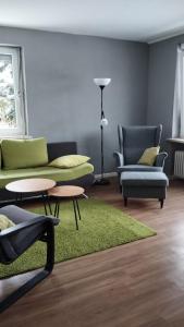 ein Wohnzimmer mit 2 Sofas und einem grünen Teppich in der Unterkunft Sonnige 60m² Ferienwohnung für 5 Personen in Bad Lauterberg