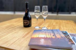 a book and two wine glasses on a wooden table at Studio Place des Lices - K1 in Saint-Tropez