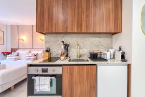 a kitchen with a sink and a bed in a room at Studio Place des Lices - K1 in Saint-Tropez