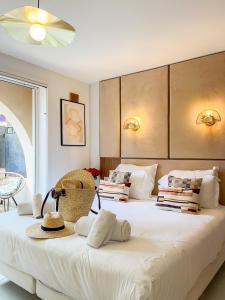 a bedroom with a large white bed with hats on it at Studio Place des Lices - K1 in Saint-Tropez