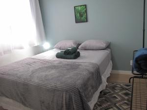 a bedroom with a bed with a stuffed animal on it at RCM Vilas - Apartamento n 12 in Joinville
